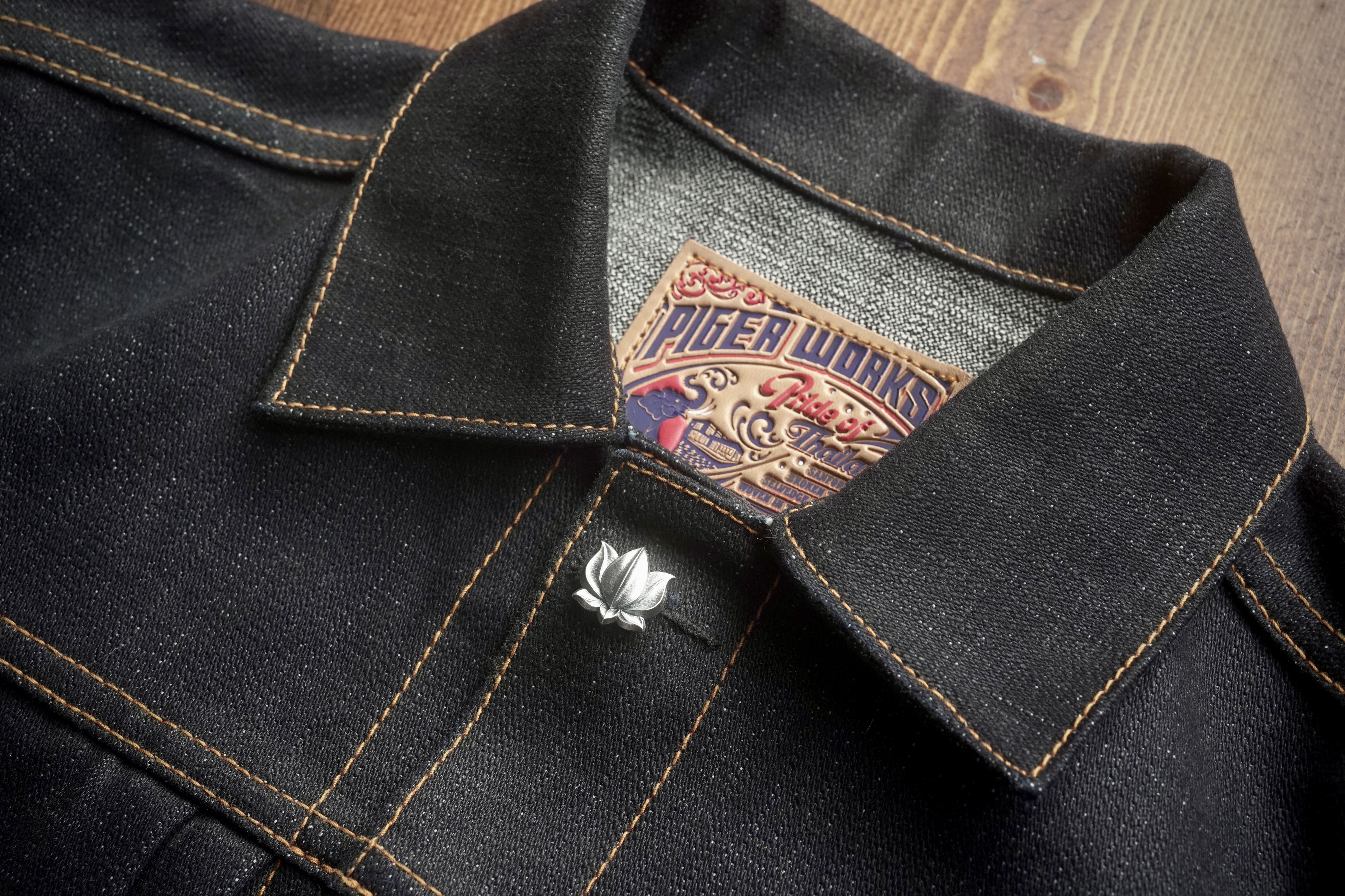 Sterling silver lotus pin on a Piger Works selvedge denim jacket collar