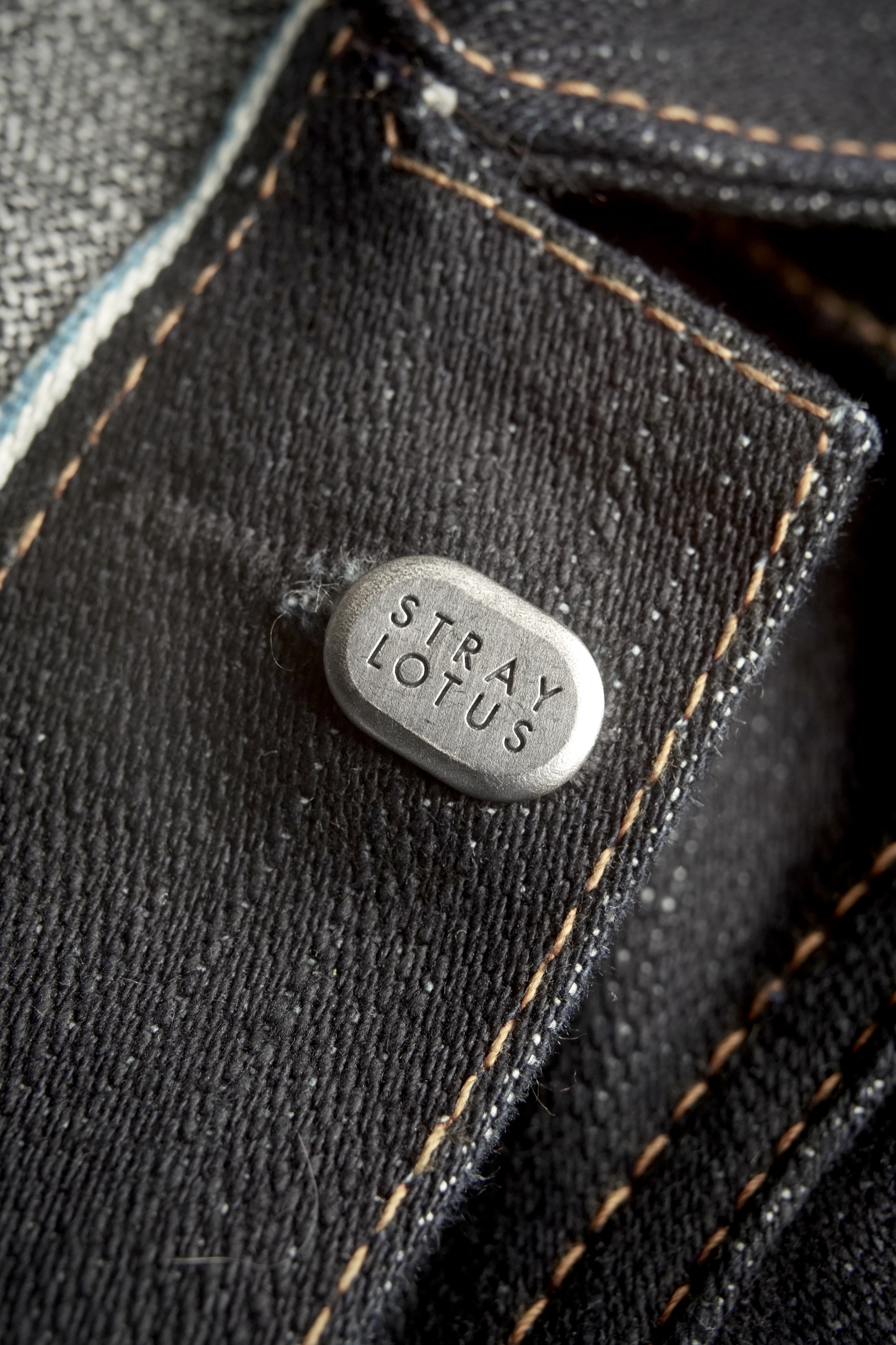 STRAY LOTUS stamped sterling pin on dark selvedge denim