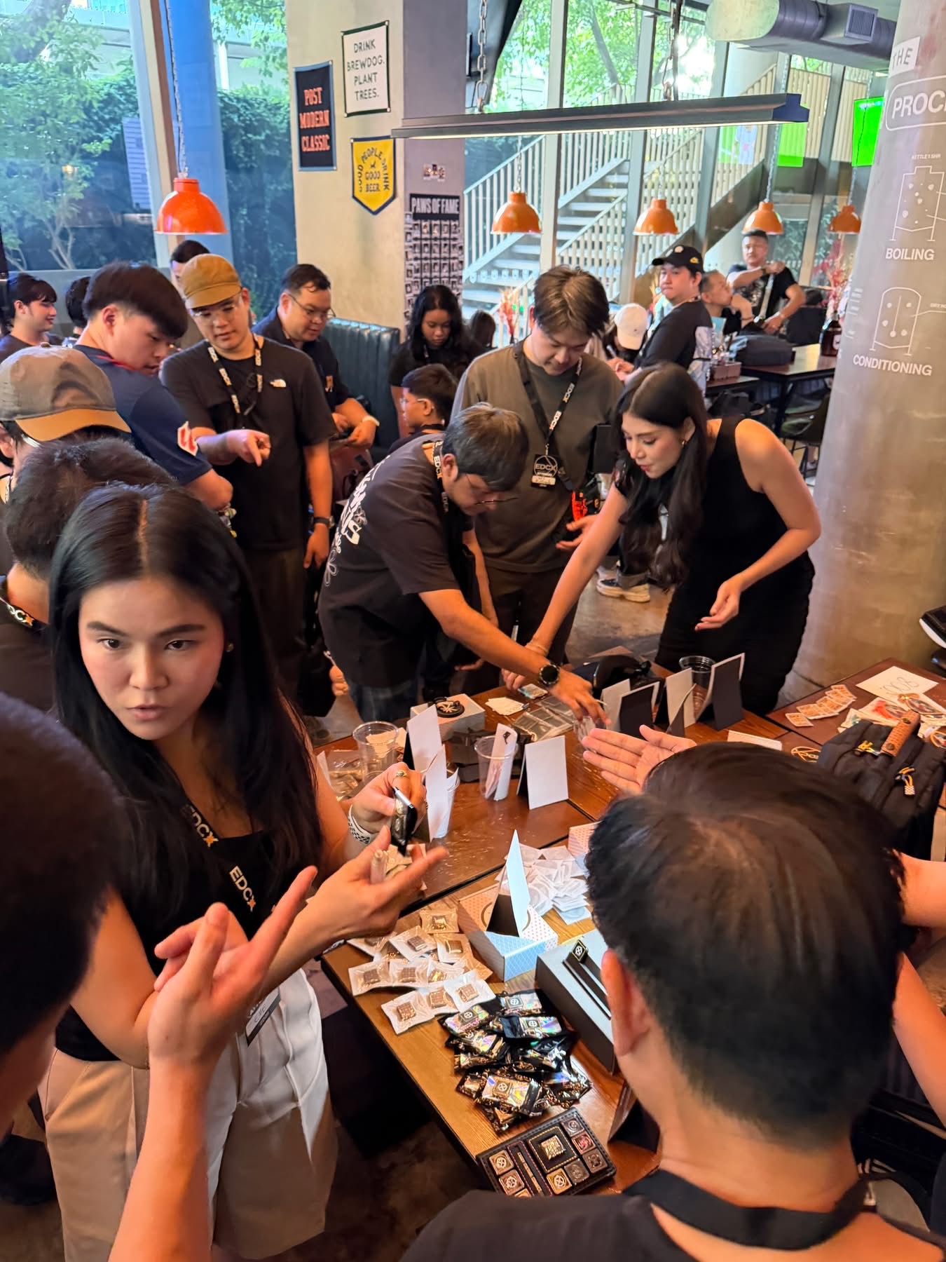 People reaching across a table of silver pieces and packaging