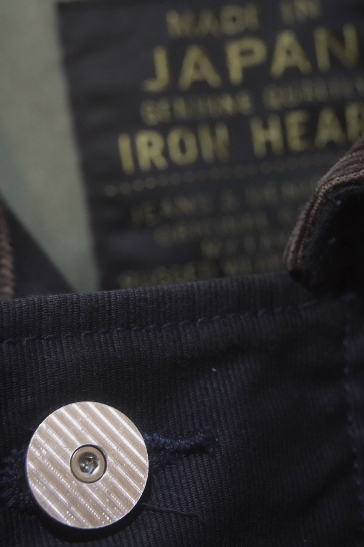 An early prototype fitted through the buttonhole of a dark jacket placket
